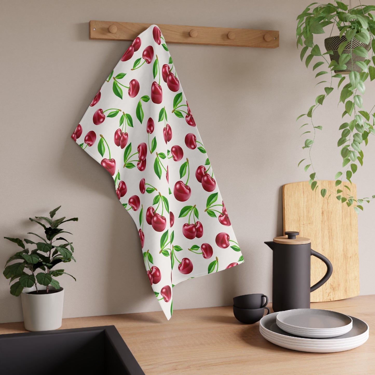 White tea towel featuring a vibrant cherry print with green leaves.