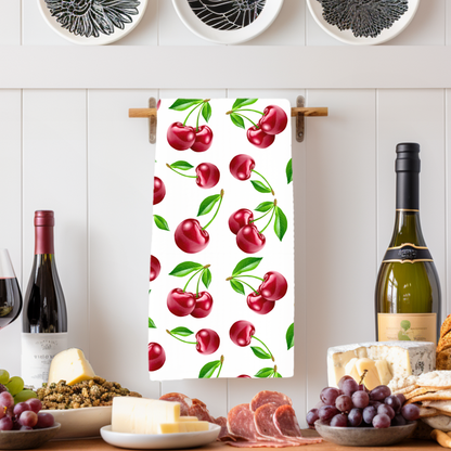 White tea towel featuring a vibrant cherry print with green leaves.