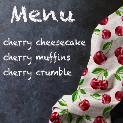 White tea towel featuring a vibrant cherry print with green leaves.