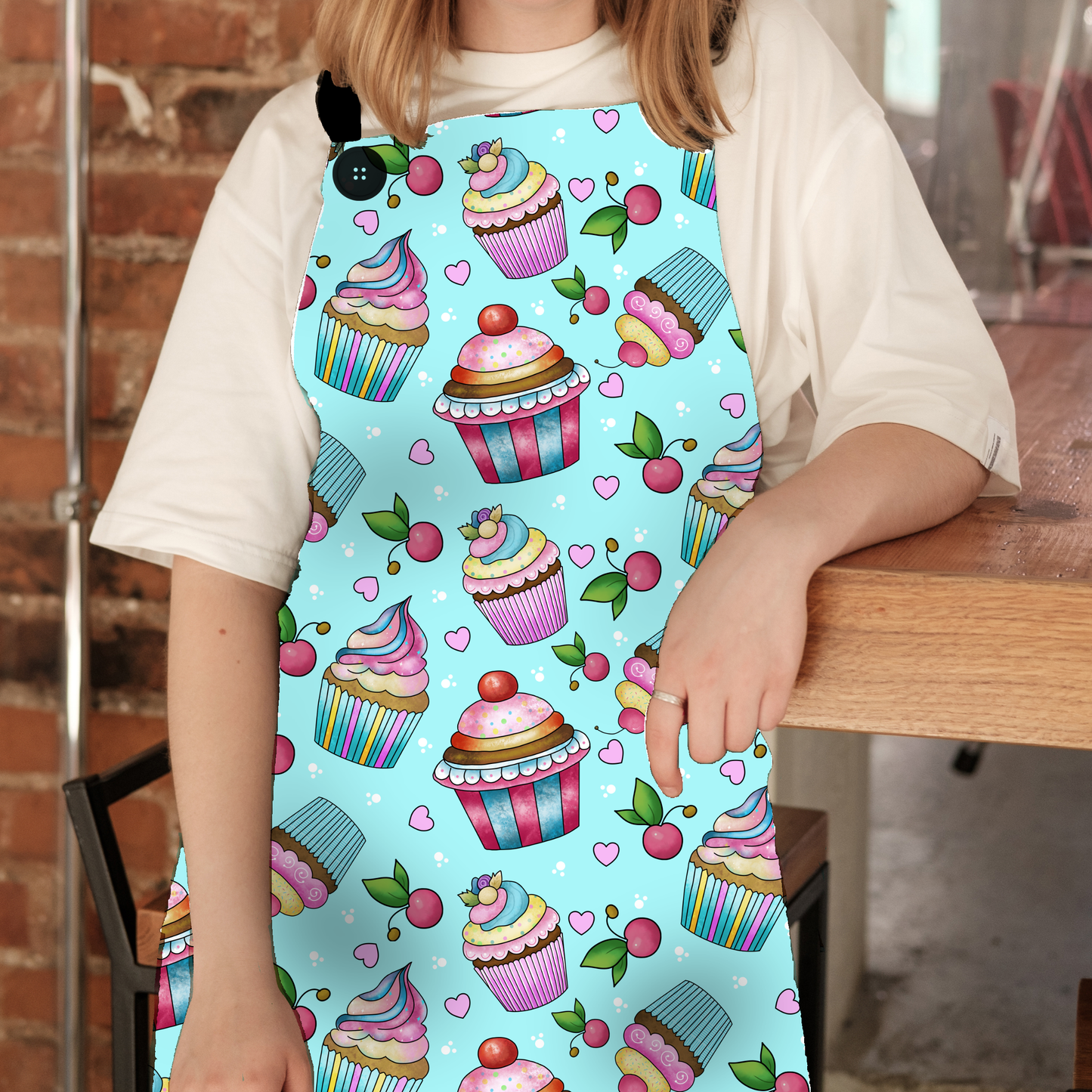 The Whimsical Cupcake Apron, brings a dash of sweetness to your kitchen with a fun and super-sweet design! Featuring a vibrant aqua background and adorable cupcake illustrations